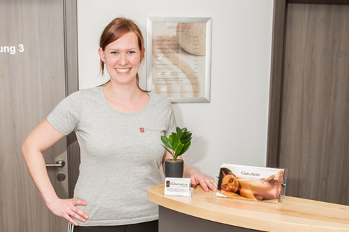Katharina Hör, Physiotherapeutin, lächelnd am Empfangstresen ihrer Praxis in Weiherhammer